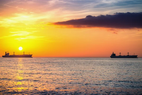 Navio de carga navegando ao nascer do sol perto da praia — Fotografia de Stock