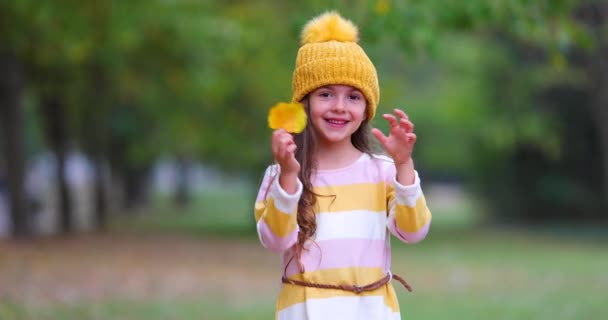 Ευτυχισμένο Νεαρό Κορίτσι Που Παίζει Πεσμένα Φύλλα Χρώματος Στο Φθινοπωρινό — Αρχείο Βίντεο
