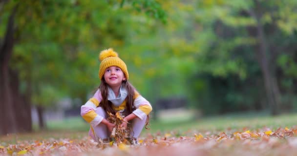 Ευτυχισμένο Νεαρό Κορίτσι Που Παίζει Πεσμένα Φύλλα Χρώματος Στο Φθινοπωρινό — Αρχείο Βίντεο