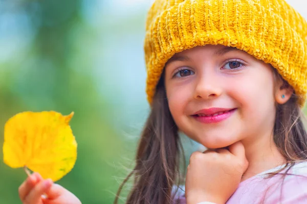 秋の公園で紅葉と遊ぶ幸せな若い女の子の肖像画 秋の木々の上で楽しむ小さな子供 — ストック写真