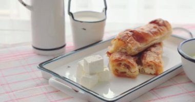 Sabah kahvaltısı taze ev yapımı peynirli börek ve sütlü yoğurt, 4K yemek videosu.