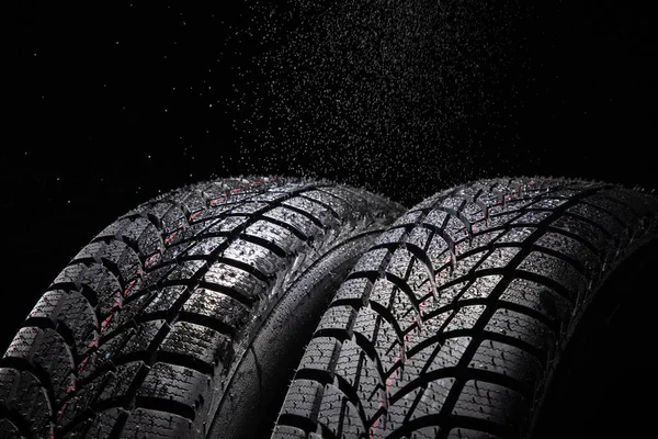 冬の車のタイヤと雨が黒の背景に落ちる — ストック写真