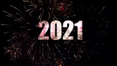 2021 yılının yeni yıl kutlamaları gece yarısı Parlayan havai fişekler ve gökyüzünde yanan parıltılarla.
