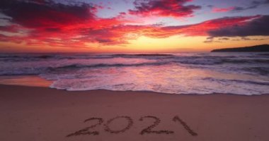 Sahildeki 2021 yılınız kutlu olsun. Gün doğumunda deniz sahilinde yazılmış bir metin, 4K video.