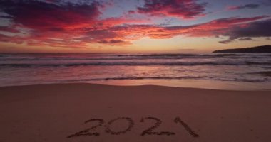 2021 yeni yıl sabahı plajda dramatik renkli bulutlar ve deniz doğuşu