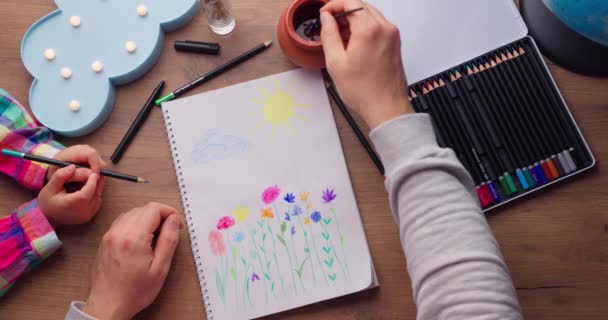 創造的なアクセサリーを持つアートワークワークプレイス 絵を描くことを娘に教える父親の作品とシートを描く 4Kビデオ — ストック動画