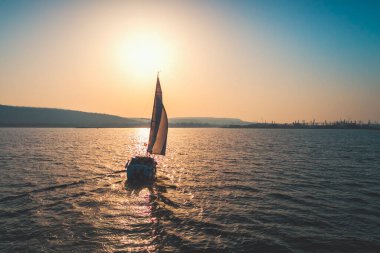 Açık denizde beyaz yelkenli yelkenli gemi. Hava - İHA görüntüsü rüzgarlı durumda yelkenliye.