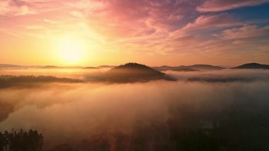 Dağ gölünün üzerinde sabah sisi, güneşin doğuşu 4k hava manzarası.