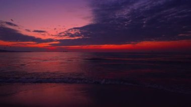 Renkli okyanus plajı gündoğumu. Deniz dalgaları kumlu kıyıları yıkıyor
