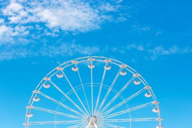 Mavi gökyüzü ve bulutlu dönme dolap