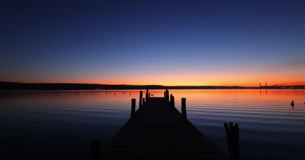 海の湖の上の古いドックと劇的な夕日 — ストック動画