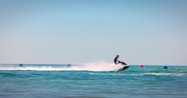 ジェットスキーをレースし 水のトリックやスプレーを作る 海で夏の楽しみ 男はジェットスキーに乗る — ストック動画