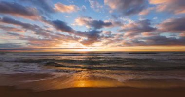 Okyanus sahili ve altın gün doğumu. Sahilde deniz kumu ve yıkanan dalgalar.