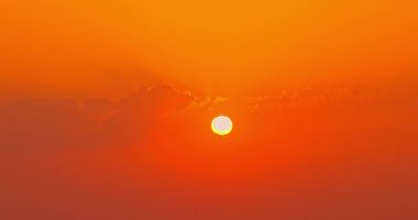 Gökyüzünde yükselen altın güneş bulutlar ve uçan kuşlarla