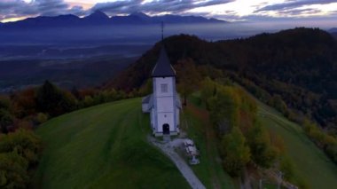 Slovenya 'nın Sava Vadisi' nin yukarısındaki tepeler ve Aziz Tomas kilisesi üzerindeki dağ manzarası, hava manzarası