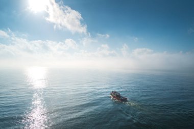 Kargo konteynır gemisinin hava görüntüsü, deniz sisi içinde yelkenler, teslimat konteynırları için çalışan vinç gemisi..   
