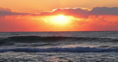 Okyanus dalgaları ve plajda güneşin doğuşu ya da batışı. 4k ağır çekim videosu