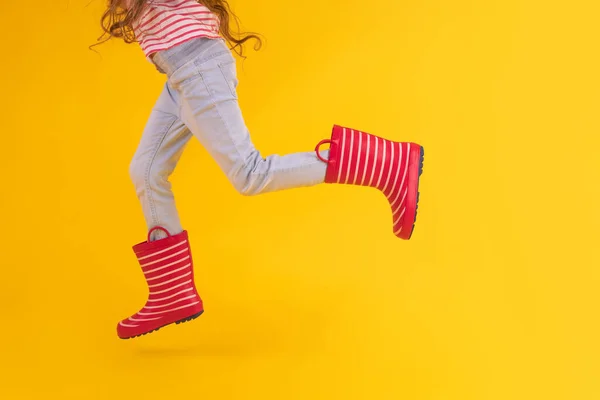 Mädchen Mit Roten Gummistiefeln Für Regen Auf Gelbem Hintergrund — Stockfoto