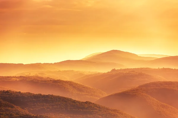 View of a valley in a beautiful early morning with fog between h — Stock Photo, Image