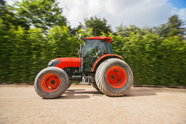 Muž s traktorem v zahradě, rozmazaný pohyb — Stock fotografie