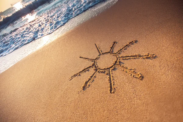 Eenvoudige zonnetekening in het zand op het strand — Stockfoto