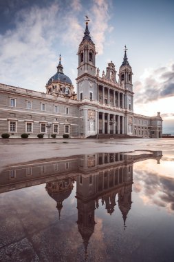 View of the Almudena Cathedral in Madrid. Reflection on a puddle. clipart