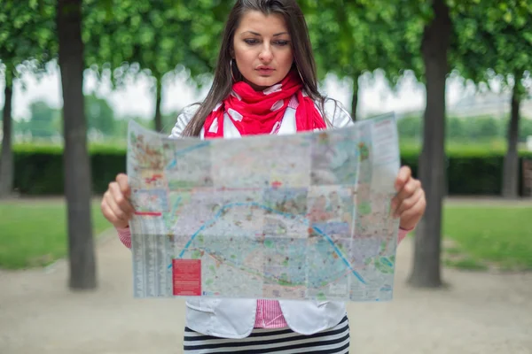 Ung kvinna som tittar på kartan på staden parkera paris, Frankrike — Stockfoto