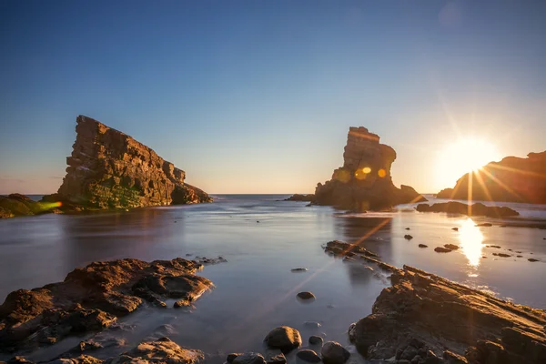 Драматичний схід сонця з туманом на пляжі з камінням — стокове фото
