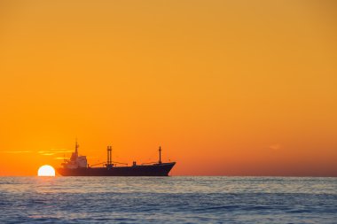 Kargo gemisi deniz harbour yakınındaki gündoğumu, yelken