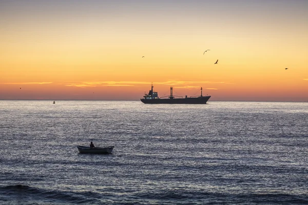 Schöner Sonnenaufgang, Fischer und Frachtschiff segeln — Stockfoto