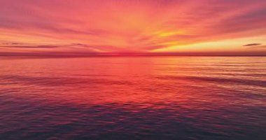 Sersemletici Deniz Günbatımı ya da Alacakaranlıkta Kırmızı ve Turuncu Dalgalar 'ın yansıtıcı yüzeyi ile Sakin Okyanus Suyunda Gün Doğuşunu İzle