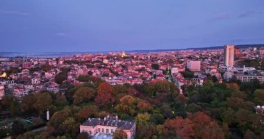 Bulgaristan 'ın Varna kentinin manzaralı panoramik kenti, dramatik gündoğumu sırasında şehrin üzerinde hava aracı görüntüsü
