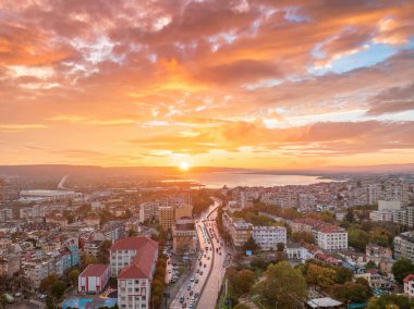 Varna şehri ve Varna Gölü üzerinde renkli günbatımı, havadan panoramik dron şehir manzarası