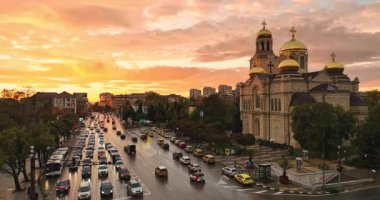 Bulgaristan 'ın Varna şehir merkezi üzerindeki hava panoramik manzarası. Şehir manzarası Assumption Katedrali, Asparuhovo Köprüsü ve Varna Gölü, insanlar ve gün batımında trafik arabaları 