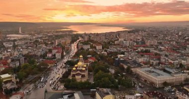 Bulgaristan 'ın Varna şehir merkezi üzerindeki hava panoramik manzarası. Şehir manzarası Assumption Katedrali, Asparuhovo Köprüsü ve Varna Gölü, insanlar ve gün batımında trafik arabaları 