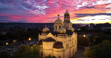 Bulgaristan 'ın Varna şehir merkezi üzerindeki hava panoramik manzarası. Şehir manzarası Assumption Katedrali, Asparuhovo Köprüsü ve Varna Gölü, insanlar ve gün batımında trafik arabaları 