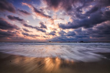 Denizin üzerinde dramatik bulutlar, güneşin doğuşu.