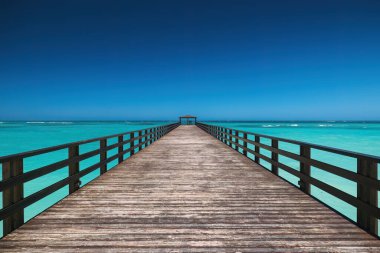 Turkuaz Denizi 'nde Uzun Ahşap İskele Mavi Gök ve Beyaz Kum Sahili' ne karşı, Punta Cana Oteli, Dominik Cumhuriyeti