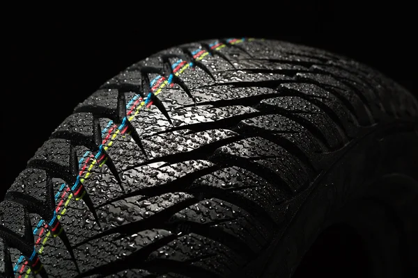 Wet car tire on black — ストック写真