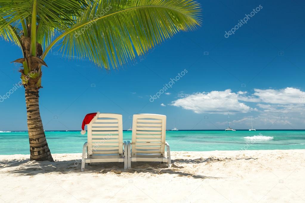 Santa's hat and sun loungers on the tropical beach