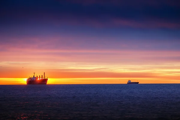 Nascer do sol sobre o mar com navio de carga à vela — Fotografia de Stock