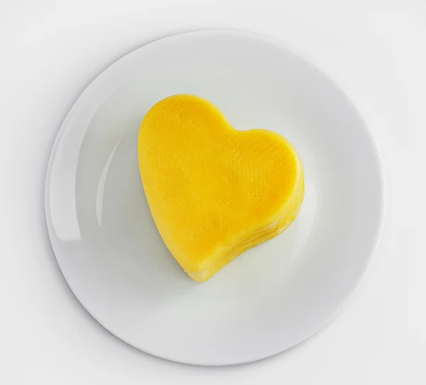 Prato com queijo em forma de coração isolado sobre fundo branco — Fotografia de Stock