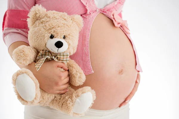 Ciąży. Kobieta w ciąży trzyma Miś zabawka w ręku, st — Zdjęcie stockowe