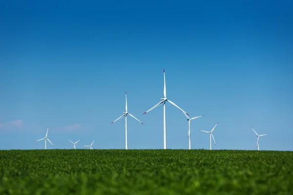 Prado verde com turbinas eólicas gerando eletricidade — Fotografia de Stock