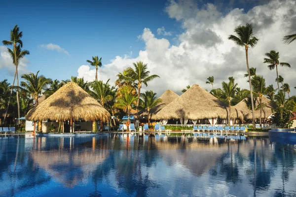 Nascer do sol sobre a piscina tropical em resort de luxo, Punta Cana — Fotografia de Stock