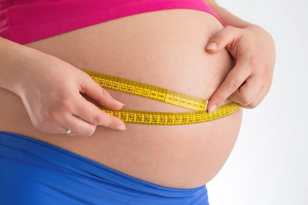 Kobieta w ciąży gospodarstwa licznik na białym tle. Conce diety i opieki zdrowotnej — Zdjęcie stockowe