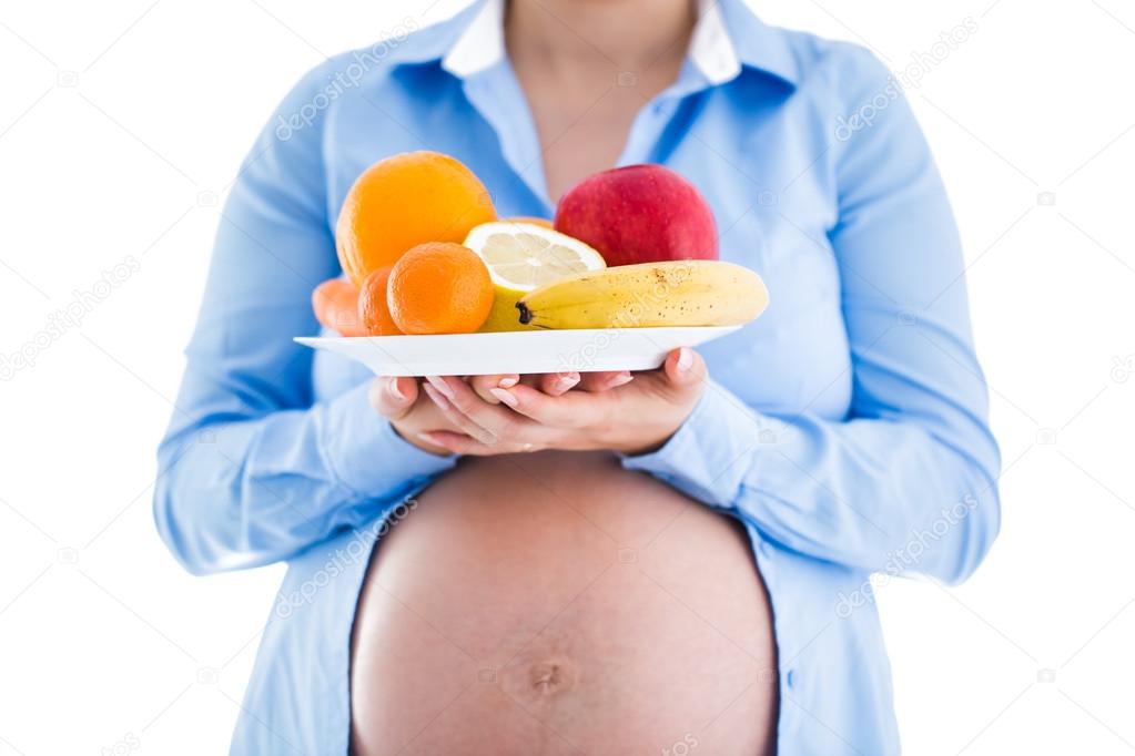 Pregnancy and nutrition diet - pregnant woman with fruits isolat