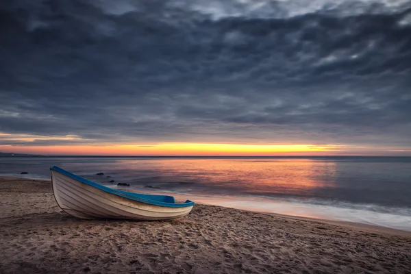 Boat and sunrise with dramatic cloudscape — Stock Photo, Image