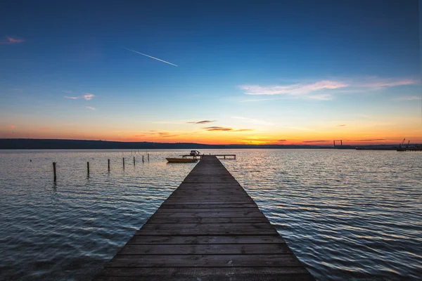 Schöne Wolkenlandschaft über dem See und blaues Boot — Stockfoto