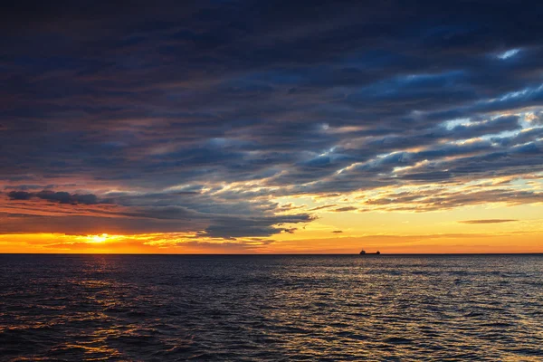 Солнце садится на море с парусным грузовым судном, живописный вид — стоковое фото